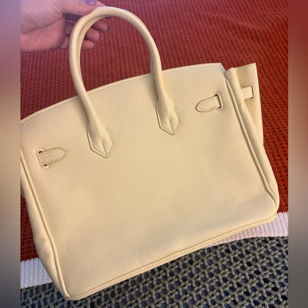 Leather hand bag, pale yellow with silver hardware.
